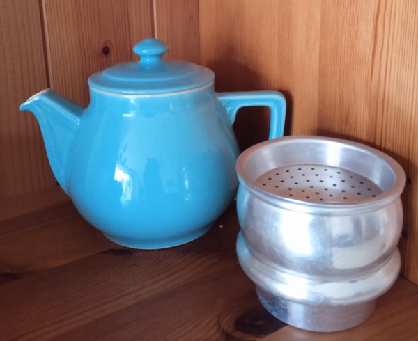 Cafetière bleue en faïence avec à ses côtés son filtre en parfait état