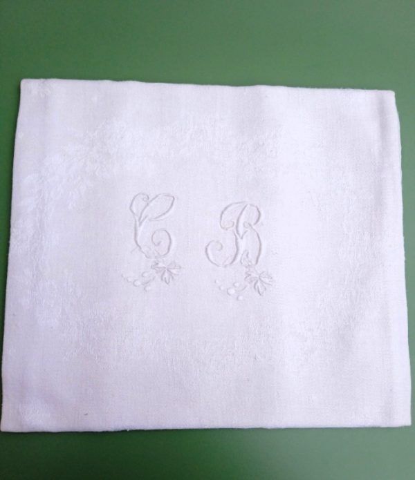 Une serviette présentée brodée aux initiales C et B